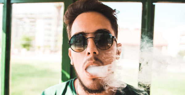 Man with sunglasses vaping the best disposable vape device